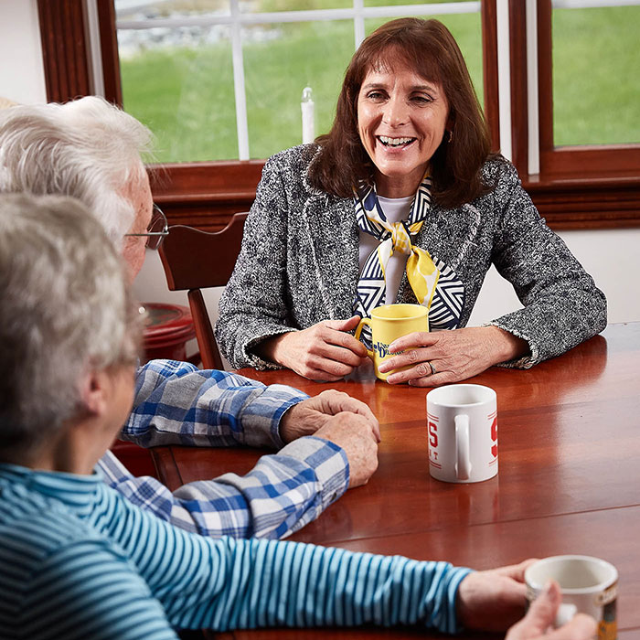 Barb Gleim enjoying coffee with two senior citizen constituents at their dining room table.